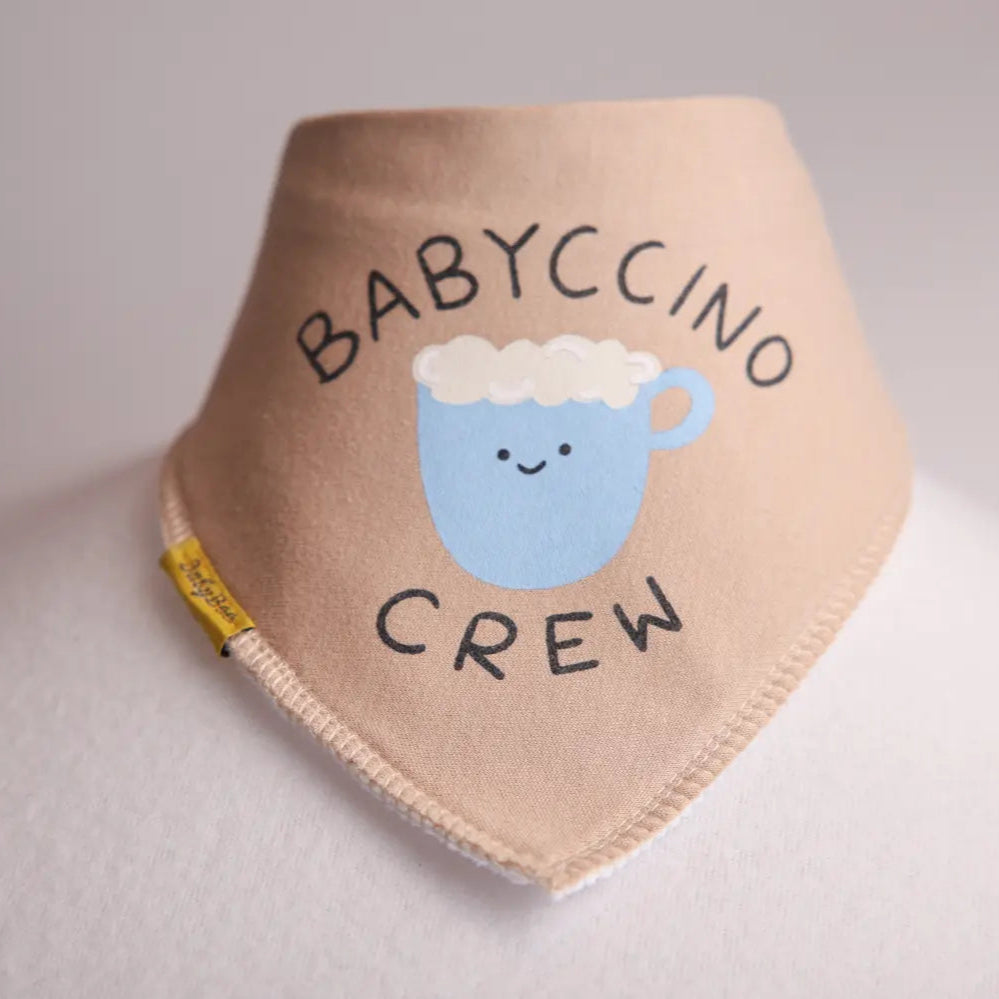 Baby bib with 'BABYCCINO CREW' text and a cartoon cup design on a neutral background