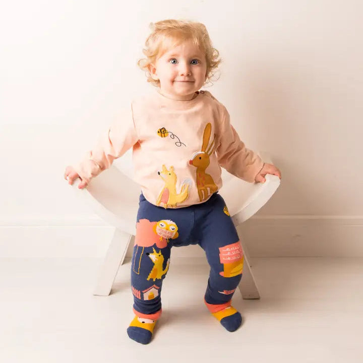 Child wearing a colorful outfit with cartoon characters on a white background