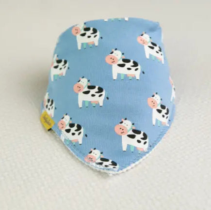 Baby bib with cow pattern on a blue background