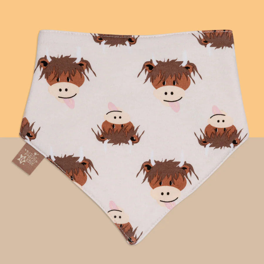 Baby bib with cow pattern on a beige background