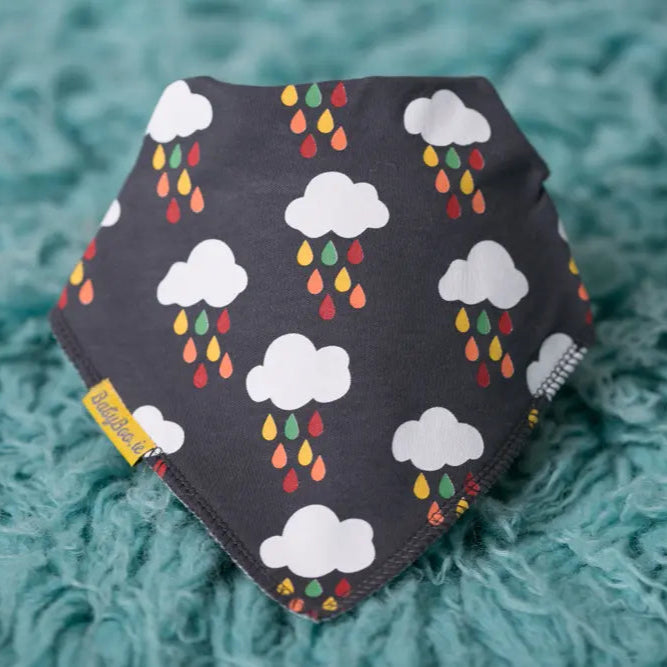 baby bib with cloud and raindrop pattern on a dark grey background