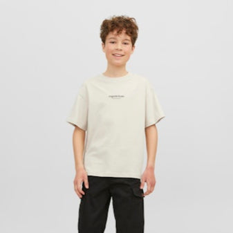 boy wearing a beige t-shirt and black pants on a white background