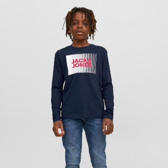 Boy wearing a navy long-sleeve shirt with a brand logo and blue jeans on a white background