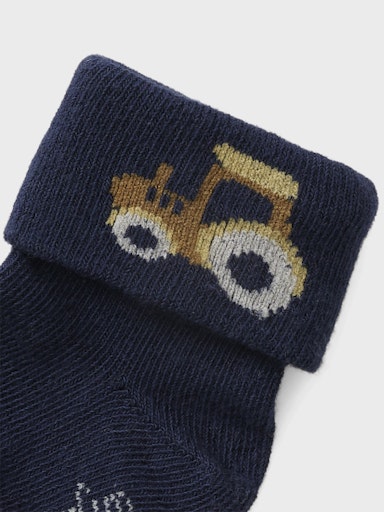 Navy blue sock with a tractor design on a light gray background