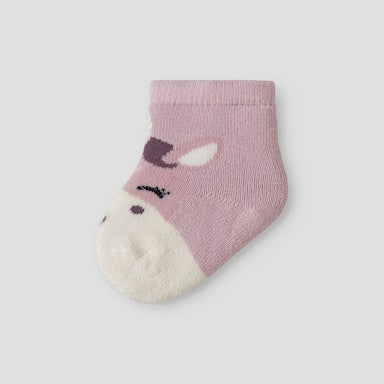 Purple baby sock with a white sole on a light  background