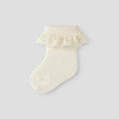 off white sock with ruffled top on a light  background