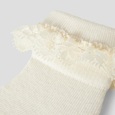 off white baby sock with lace trim on a light  background