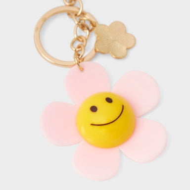 Keychain with a smiley face flower charm on a white background