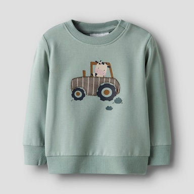 green baby sweat top with tractor and a cute cow driving it 
