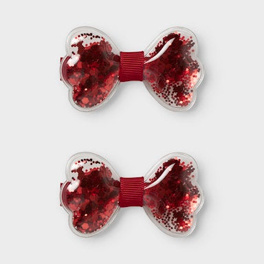 Two red glittery hair bows on a white background