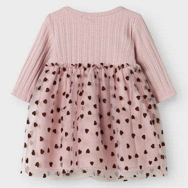 Pink dress with a tulle overlay and heart patterns on a white background